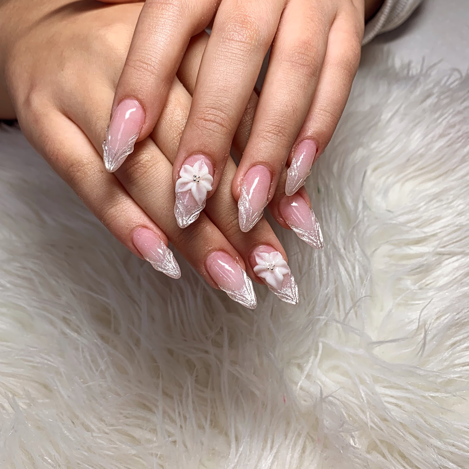 Blush nude nails with silver French edges and a sculpted 3D flower accent at B&T Nails