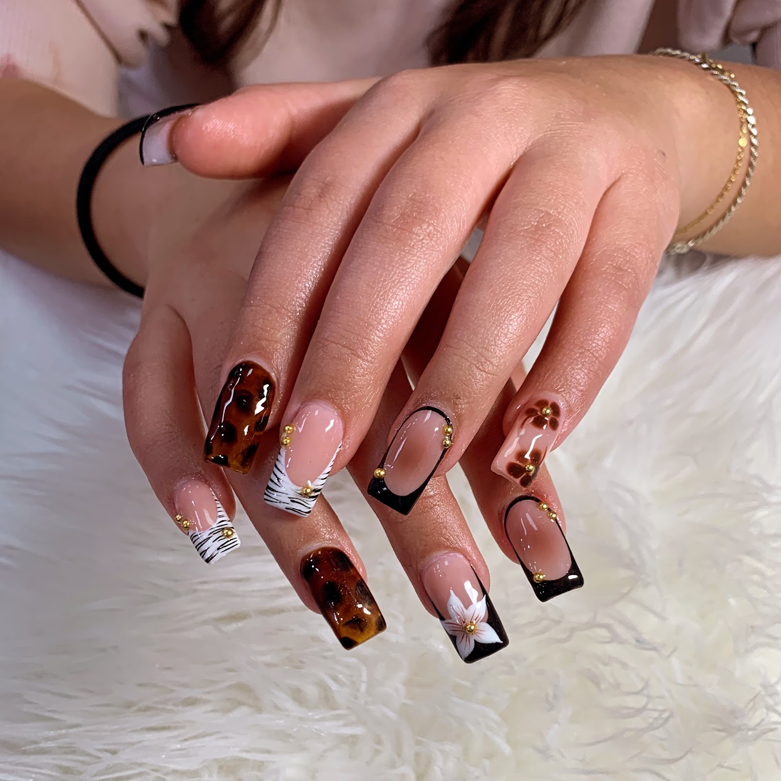 Tortoise shell and black French nail designs with gold beads at B&T Nails