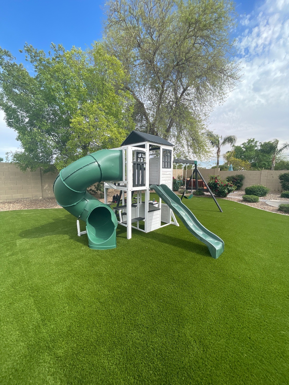 Green tube-slide playhouse on turf
