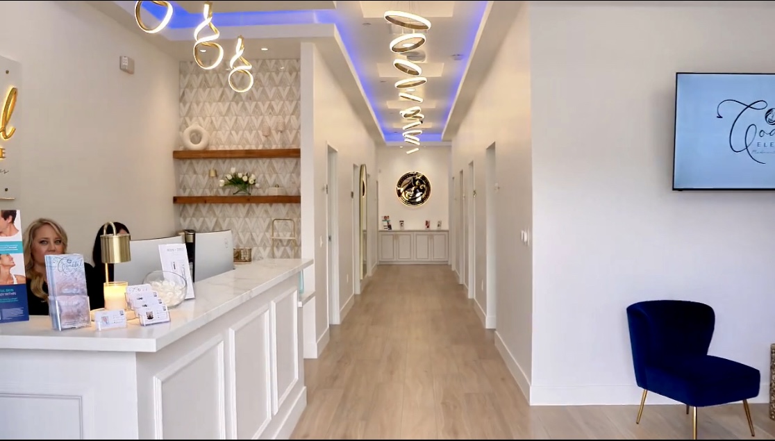 The bright, gold-accented reception and treatment hallway at Coastal Elegance