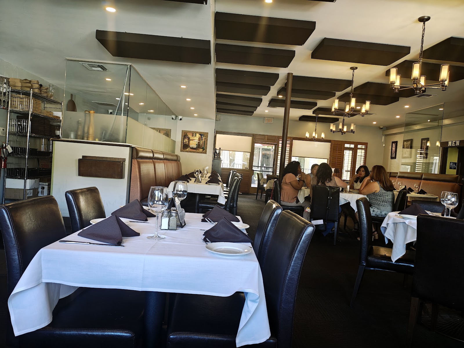 The candlelit dining room at Delizie, white linen and dark wood