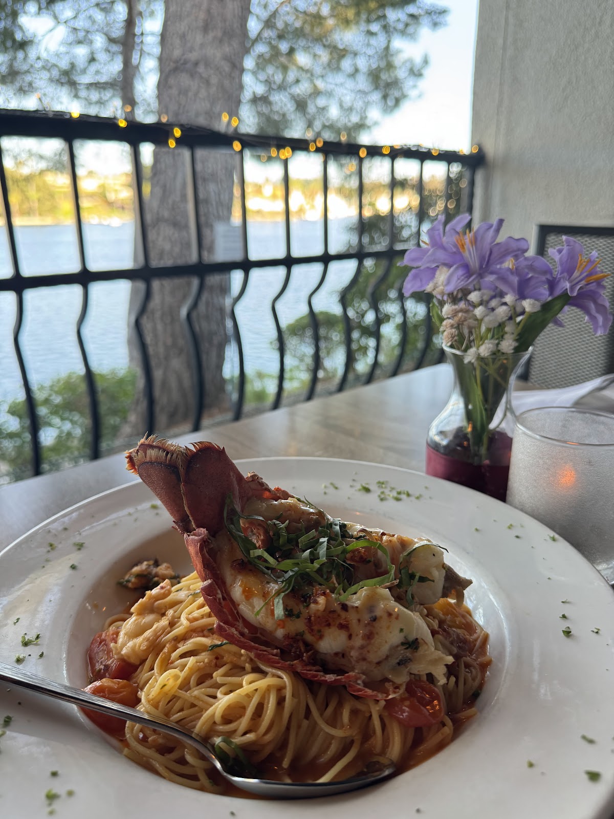 Lobster spaghetti on a Domenico's table, with Lake Mission Viejo glowing through the patio railing at sunset