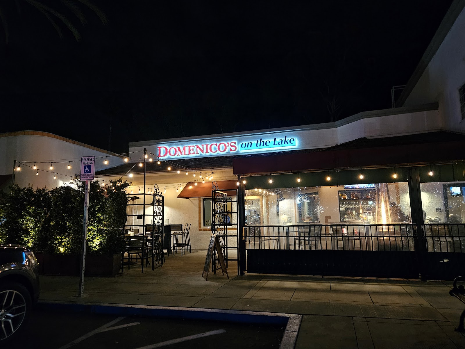 Domenico's on the Lake at night, the Domenico's sign glowing, string lights over the patio