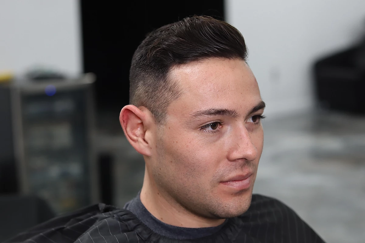 Textured pompadour with a low fade, finished at Faint Blends Barbershop