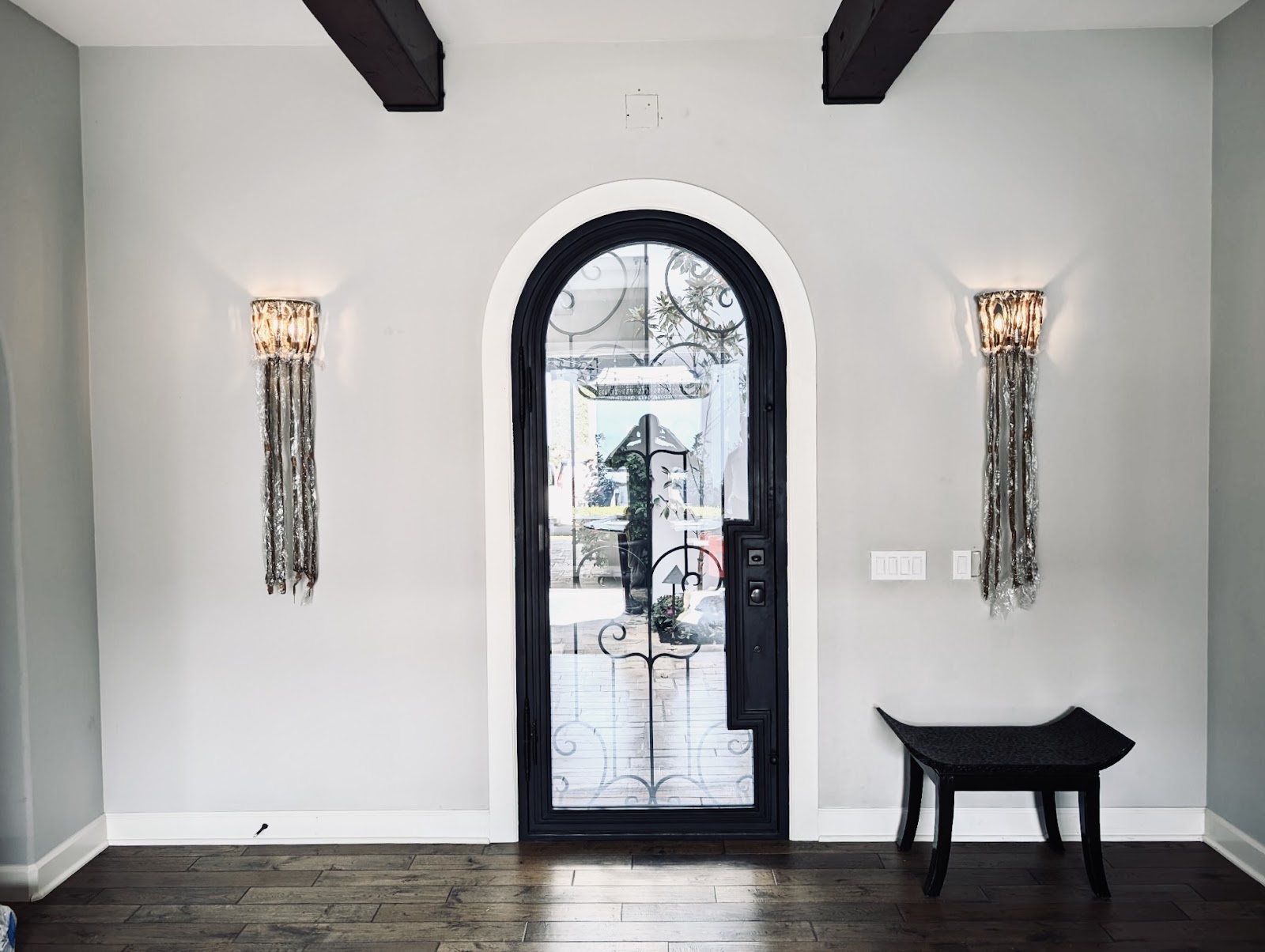 Wrought-iron entry with glass wall sconces