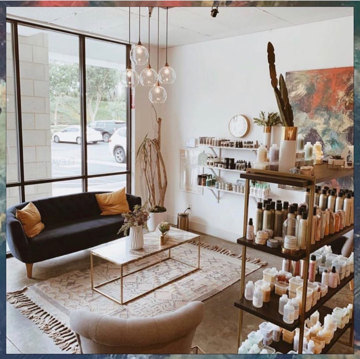 The Gold & Braid lounge, a velvet sofa with gold accents and a wall of products