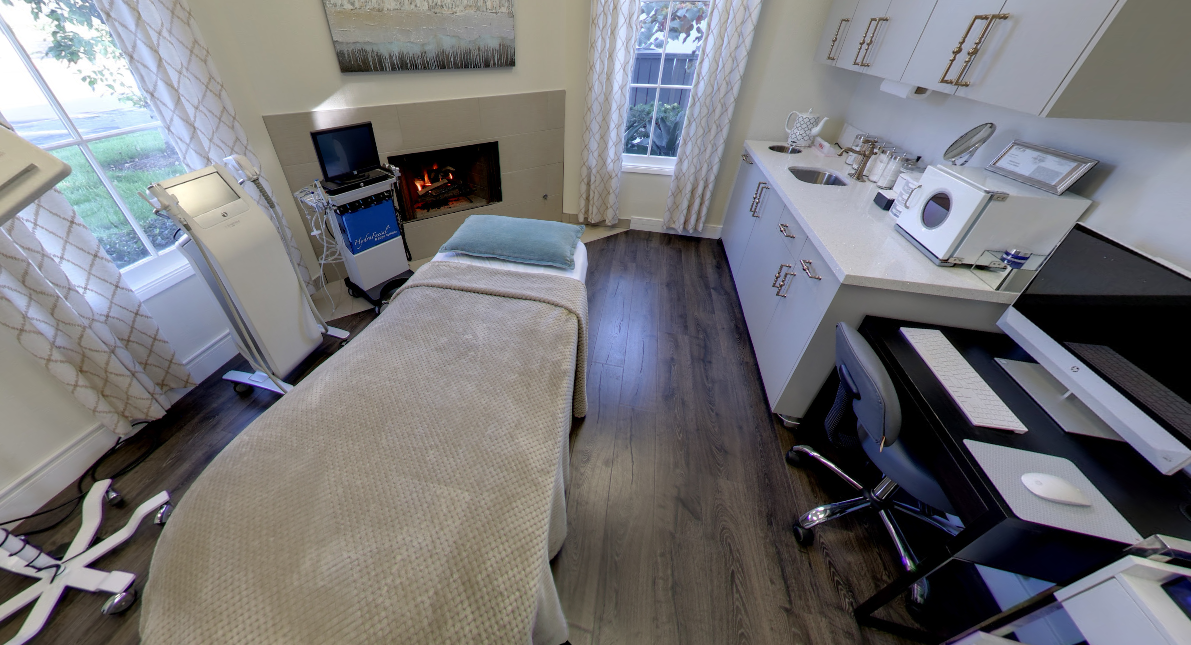A Gravity treatment room with a draped table, equipment, and a lit fireplace