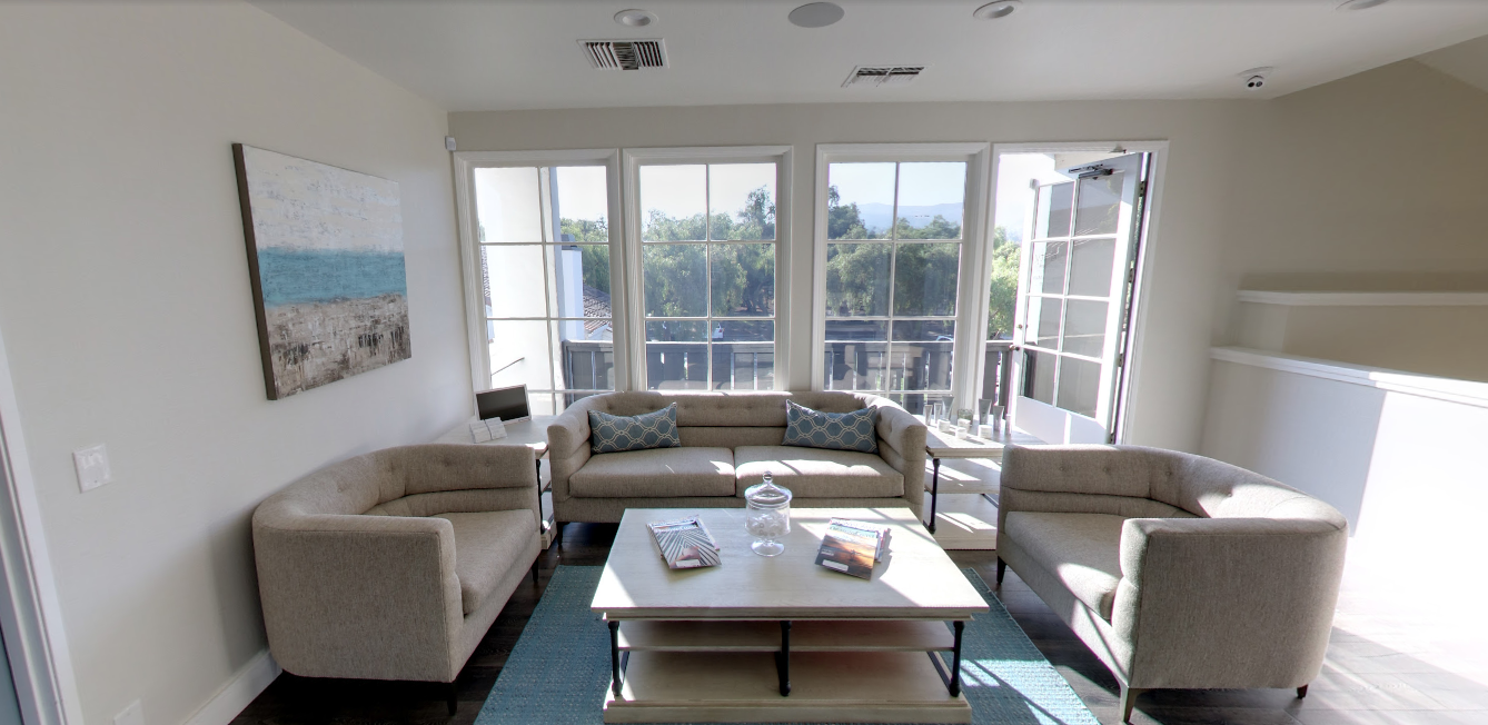 The bright Gravity lounge with neutral sofas, coastal artwork, and natural light