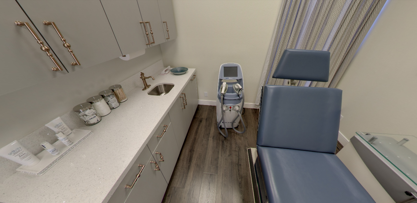 A clinical treatment room at Gravity with white cabinetry and a blue exam chair
