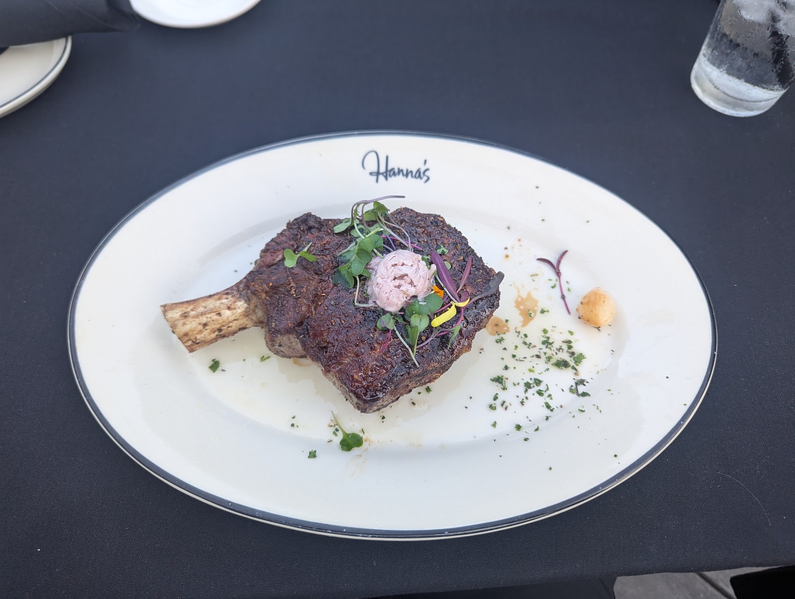 A bone-in ribeye on a Hanna's-branded plate at Hanna's Prime Steak in Rancho Santa Margarita