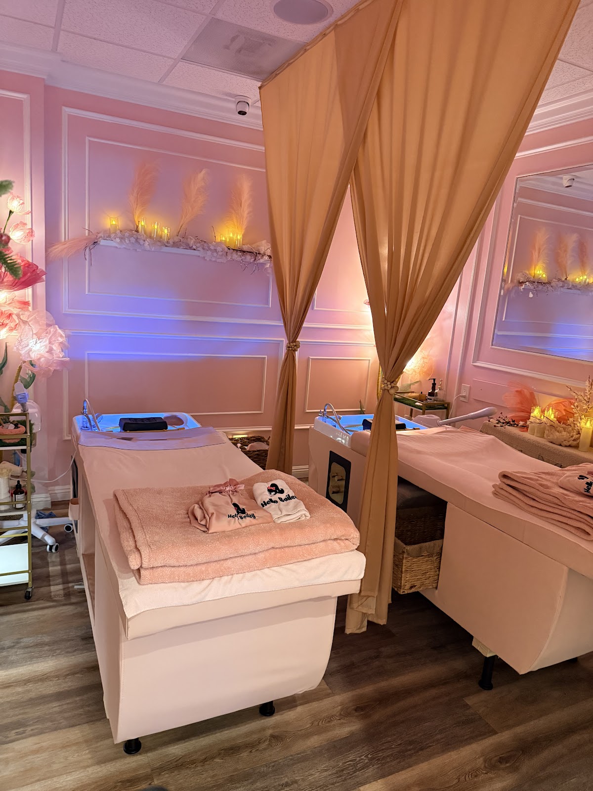 The head spa treatment room. Pink walls, gold drapes, two beds, candle ambience.