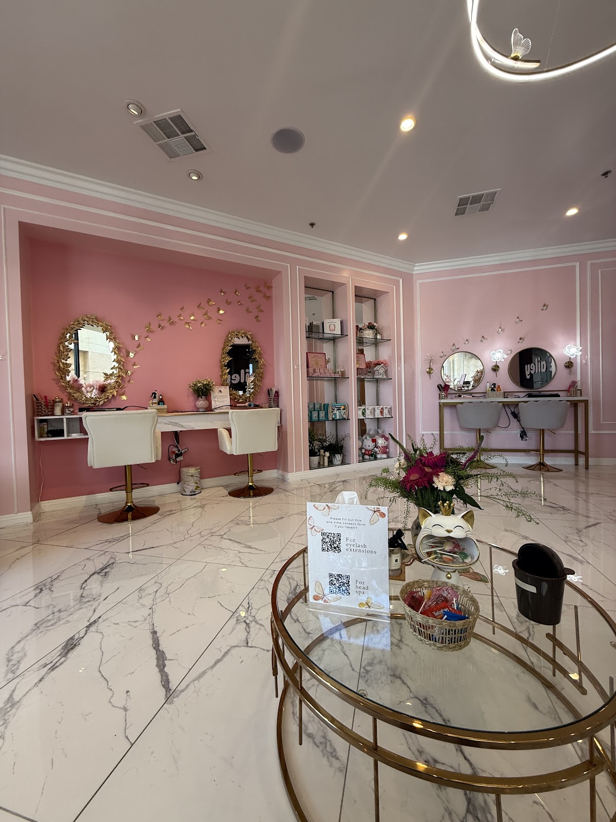 The lash studio interior at Hello Bailey. Pink walls, butterflies, marble.