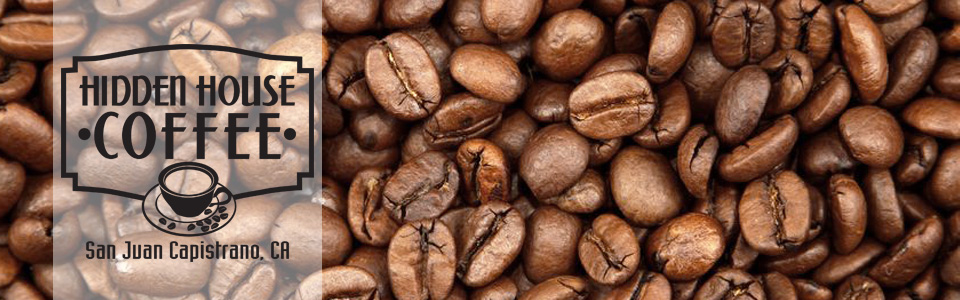 The Hidden House Coffee logo cut into a field of dark roast coffee beans
