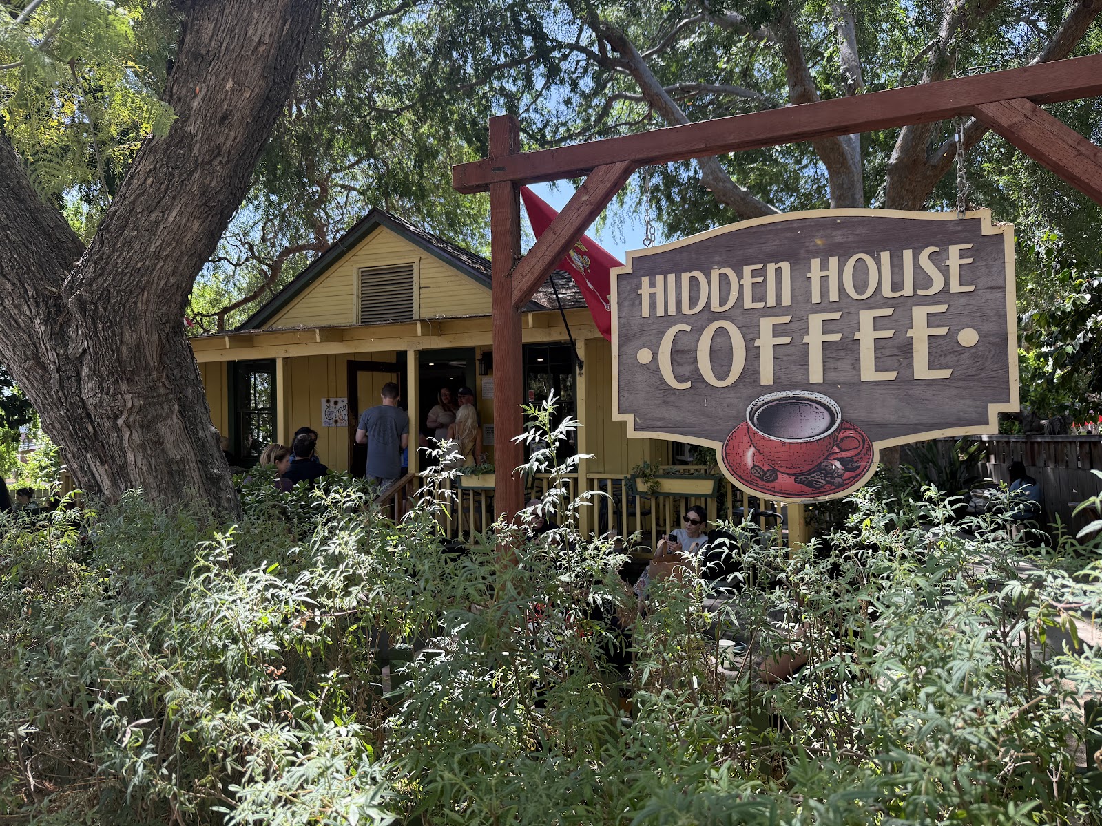 The Hidden House Coffee cottage on Los Rios Street, San Juan Capistrano, with the hand-routed wooden sign and yellow-clapboard porch