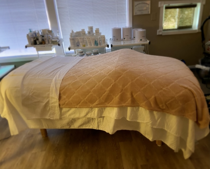 The treatment room at Honey + Cream Spa with a warm cream and honey blanket and shelves of organic products