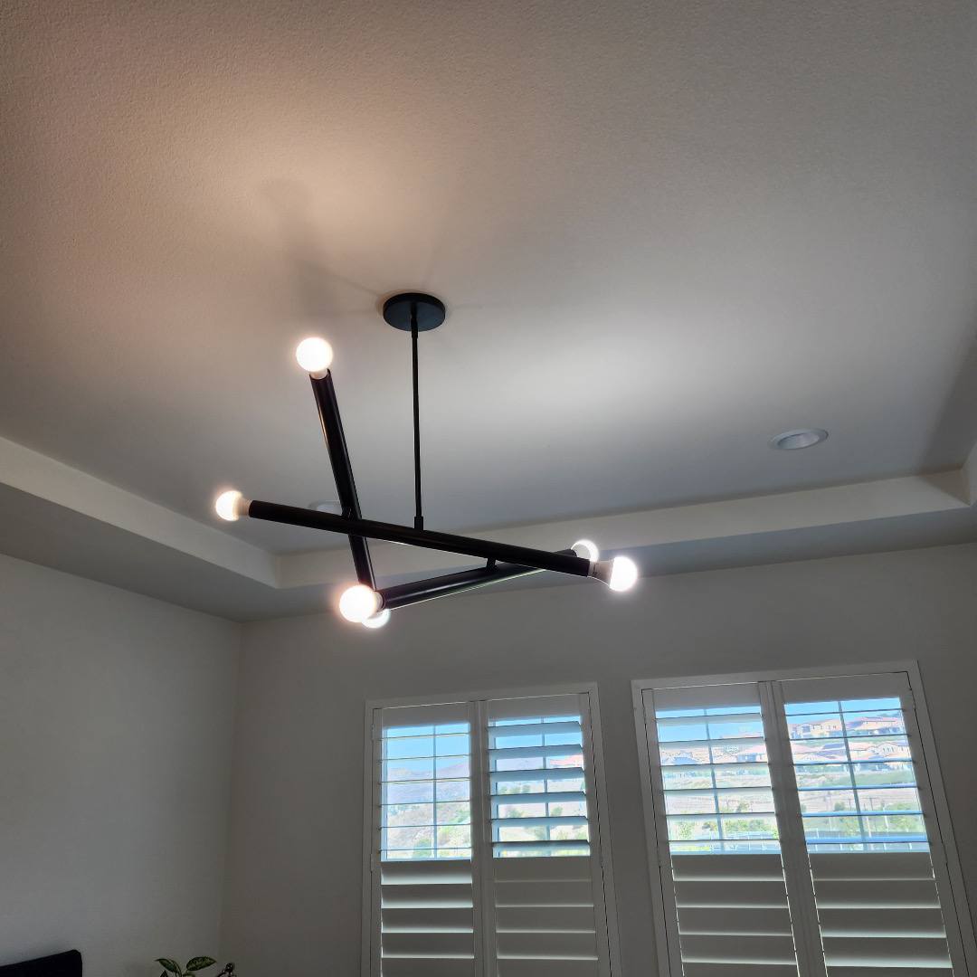 Black linear chandelier on a tray ceiling