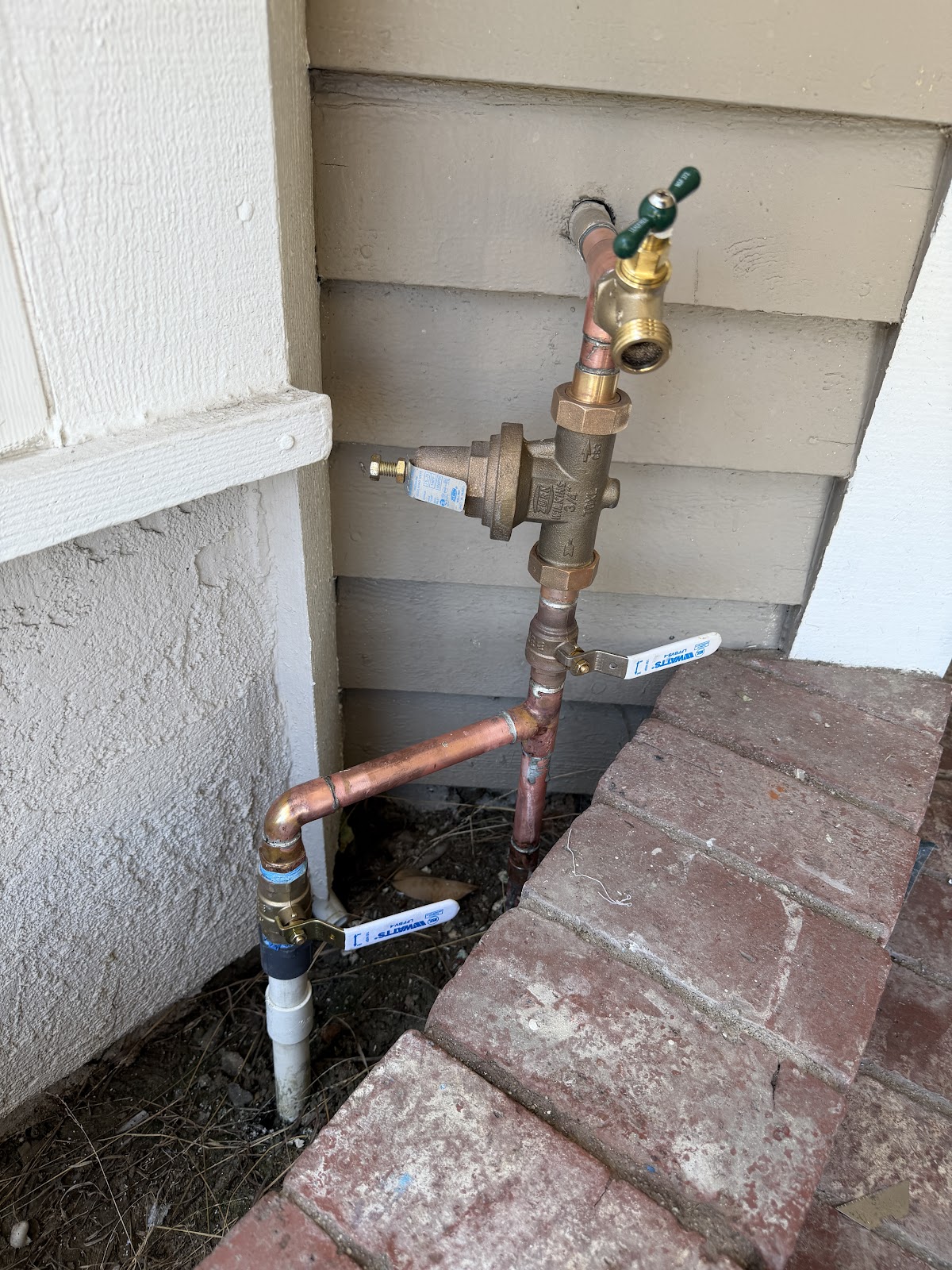 Copper repipe and backflow assembly on a home exterior by Kalka