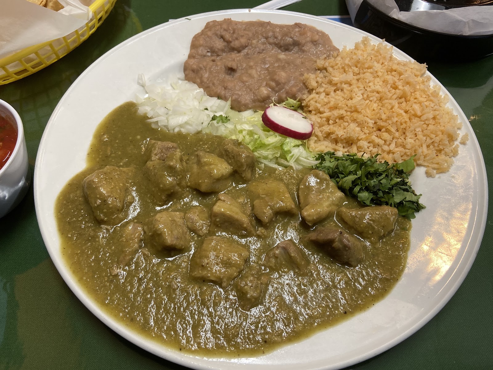 A chile verde plate at La Cocina de Ricardo with pork in green tomatillo sauce, rice and beans