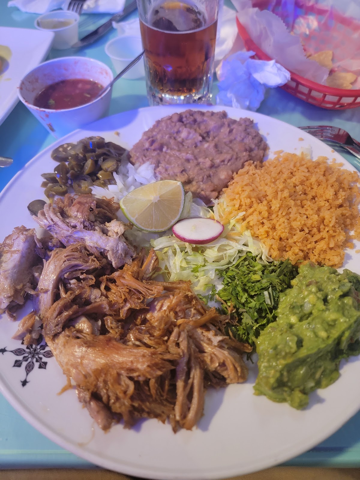 A carnitas plate at La Cocina de Ricardo with roasted pork, guacamole, beans and rice