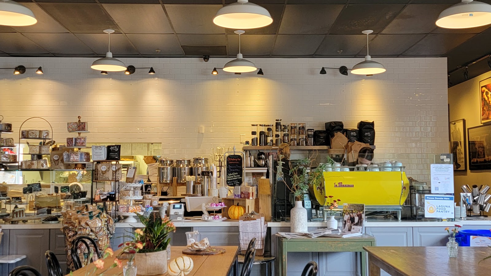 The interior of Lola's Cafe in Ladera Ranch, warm pendant lights over the espresso bar