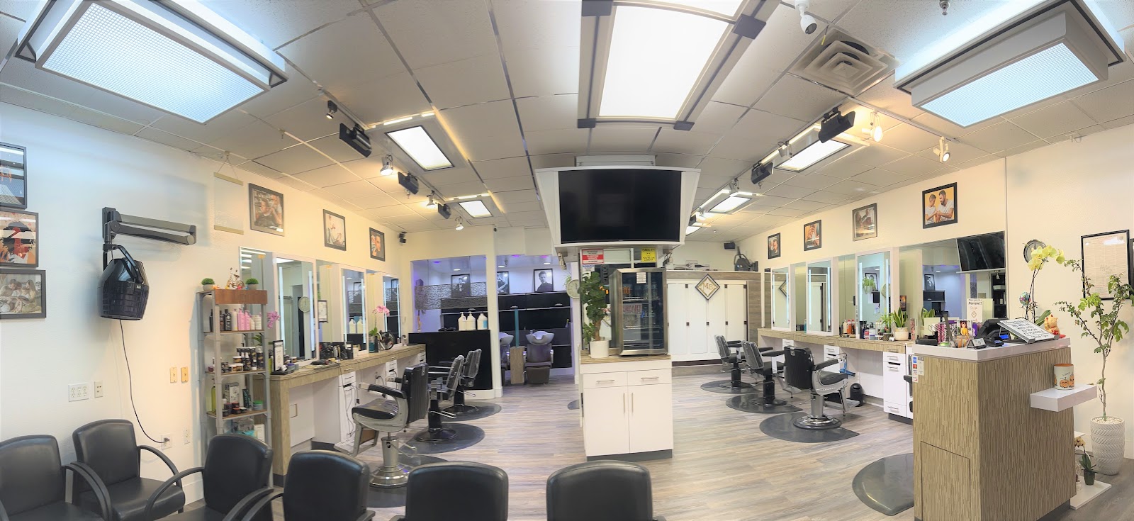 A wide interior view of Maia Bella, barber stations and mirrors lining both walls