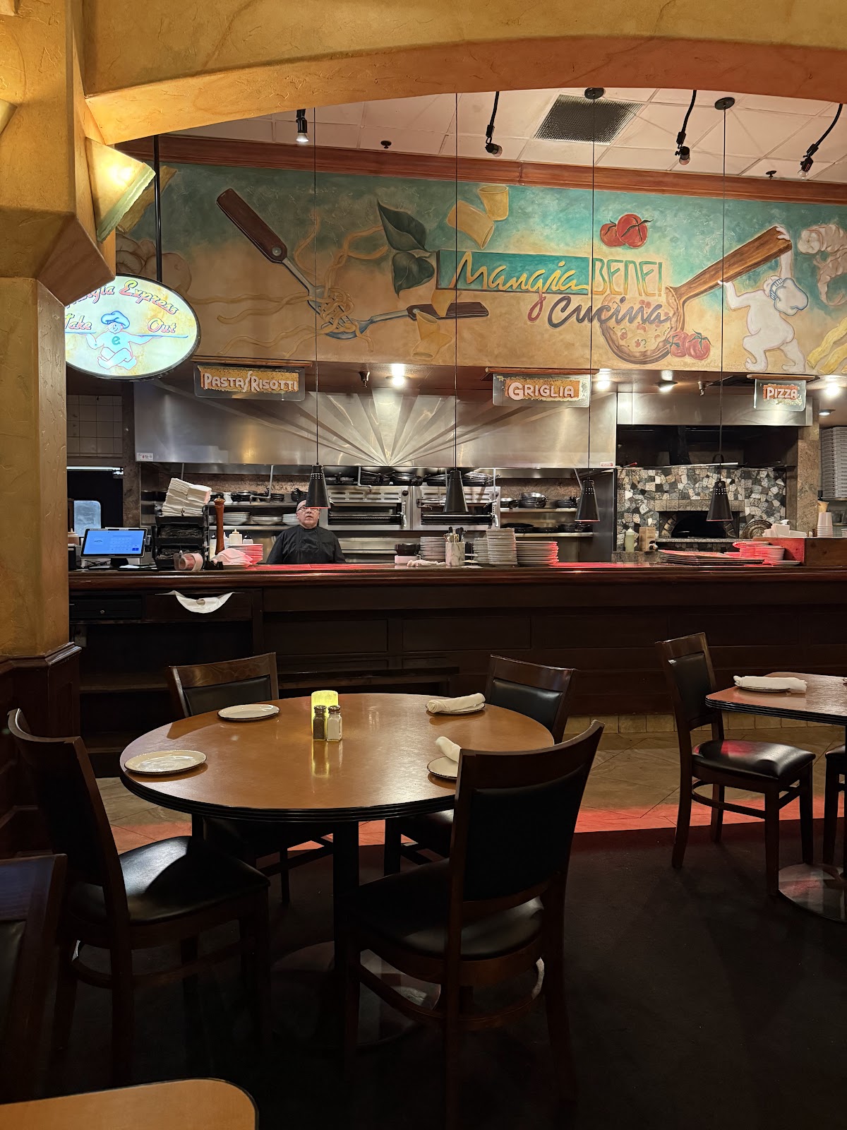 The warm, mural-painted dining room at Mangia Bene Cucina