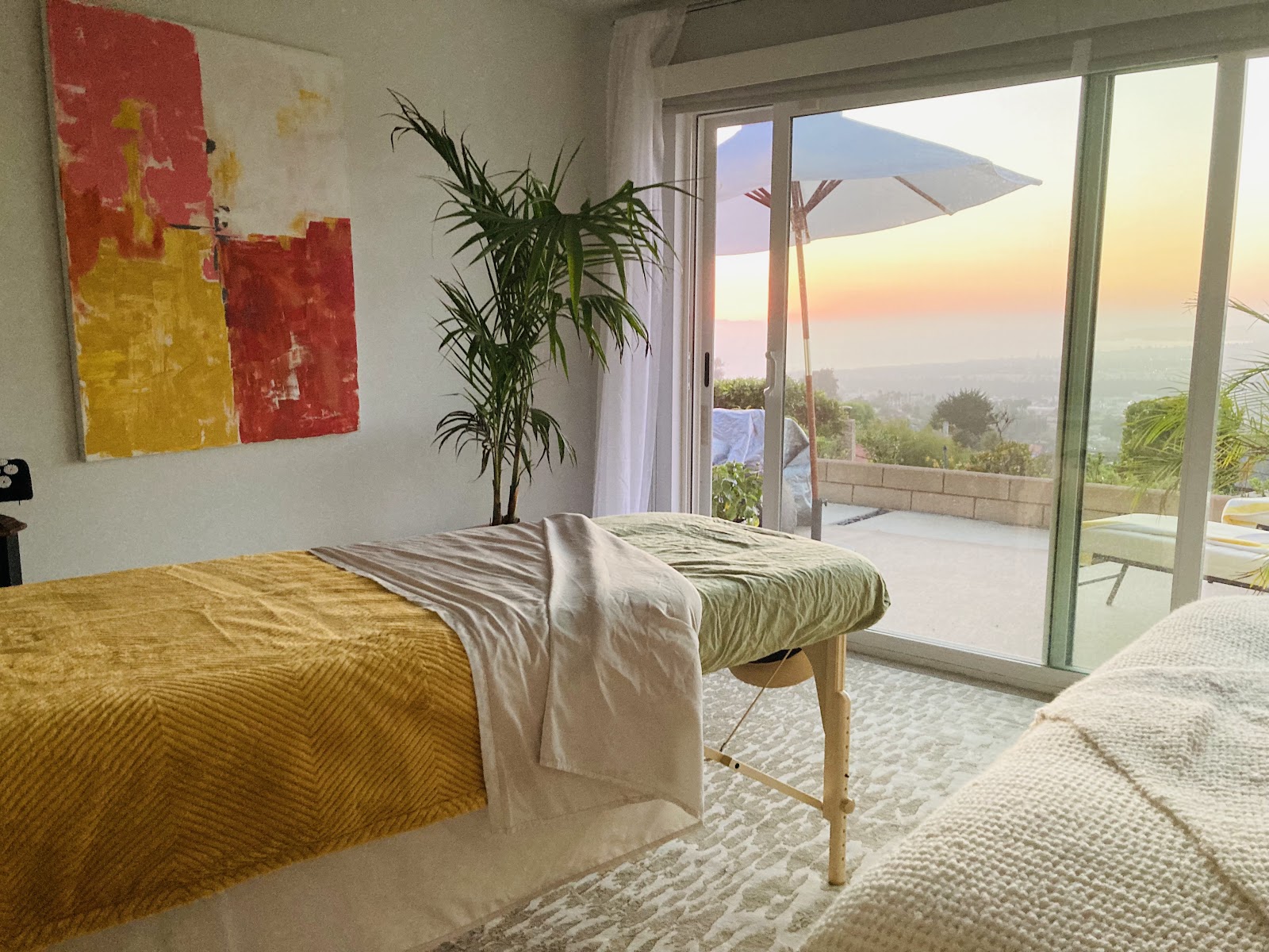 A sunlit treatment room with a sunset view