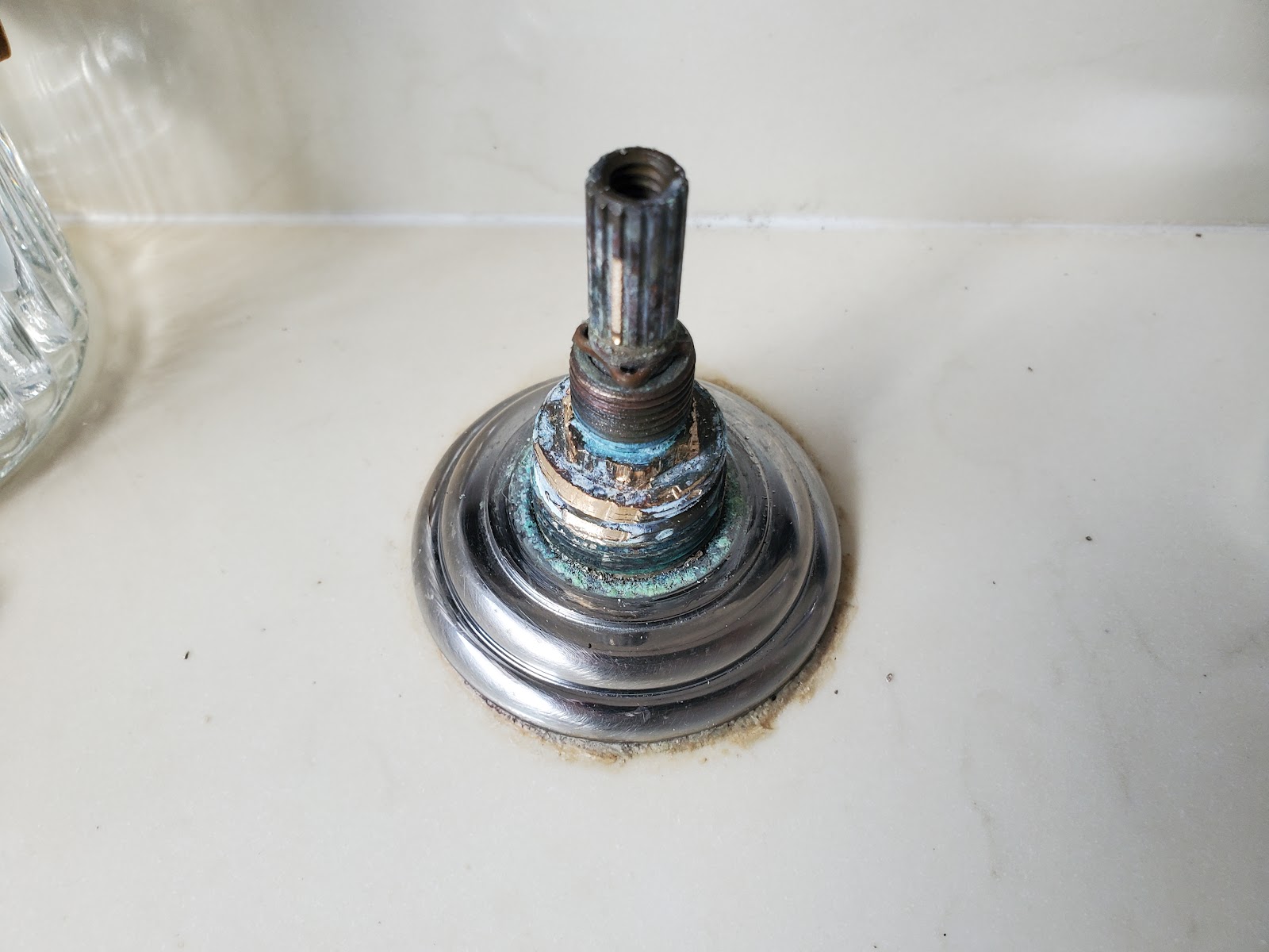 Corroded brass fixture cartridge with copper patina removed during a McKeown Plumbing repair