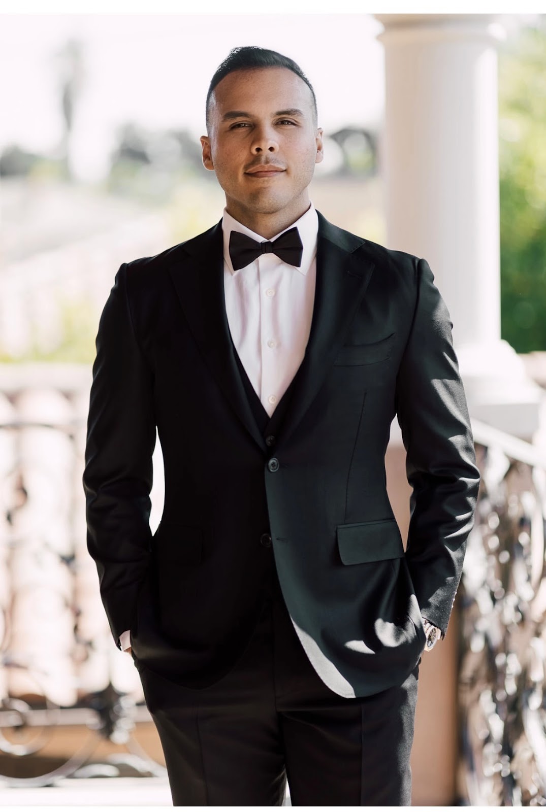 A well-groomed man dressed in a black tuxedo with bow tie, illustrating the formal-cut look offered at Meticulous Cuts.