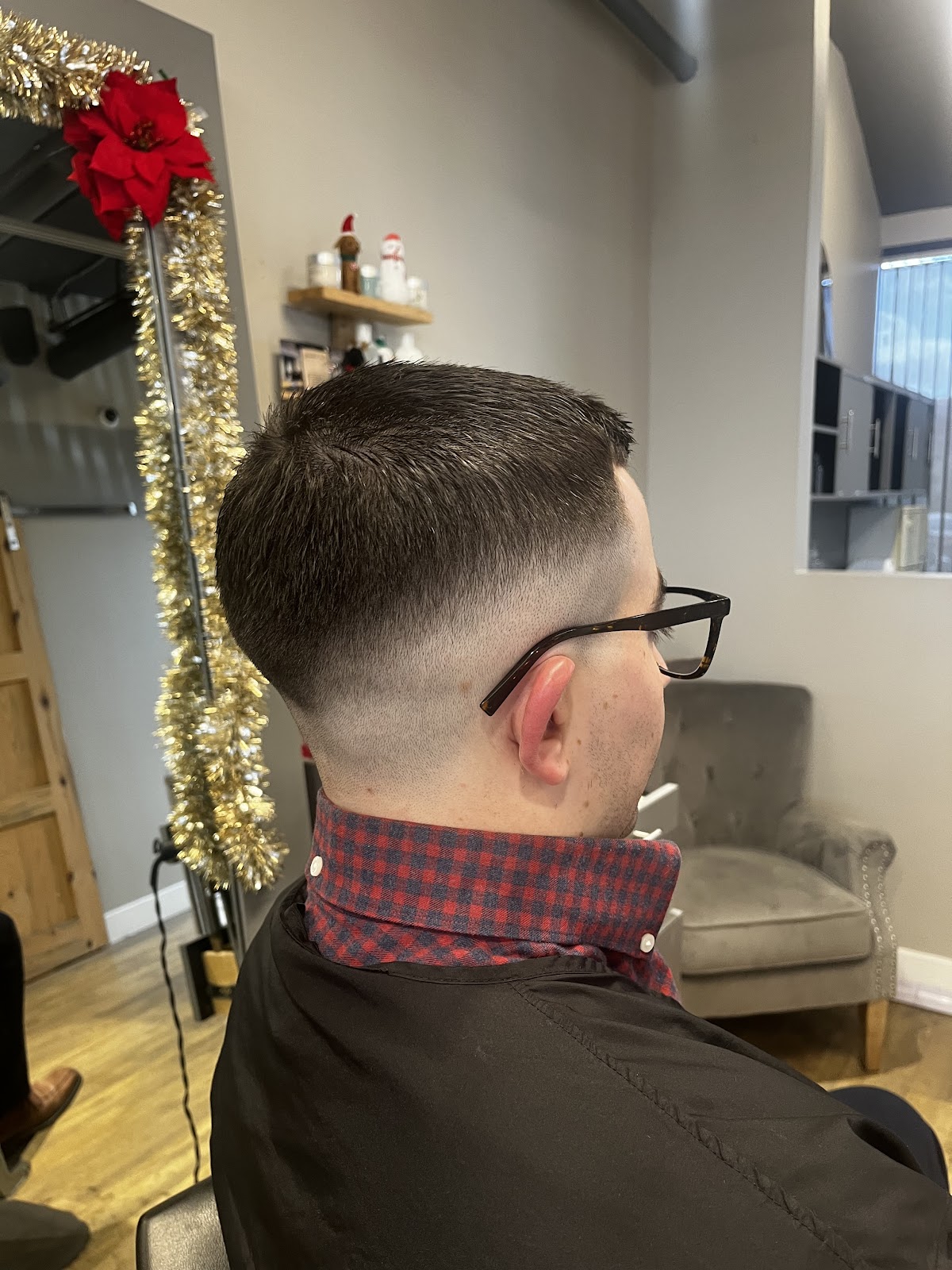 The Clean Fade. Uniform top, fade to skin at the base, line-up at the temple. The cut that holds for three weeks.