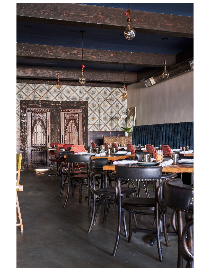 The dining room at Mint Desi Craft Kitchen, warm low light and wood finishes