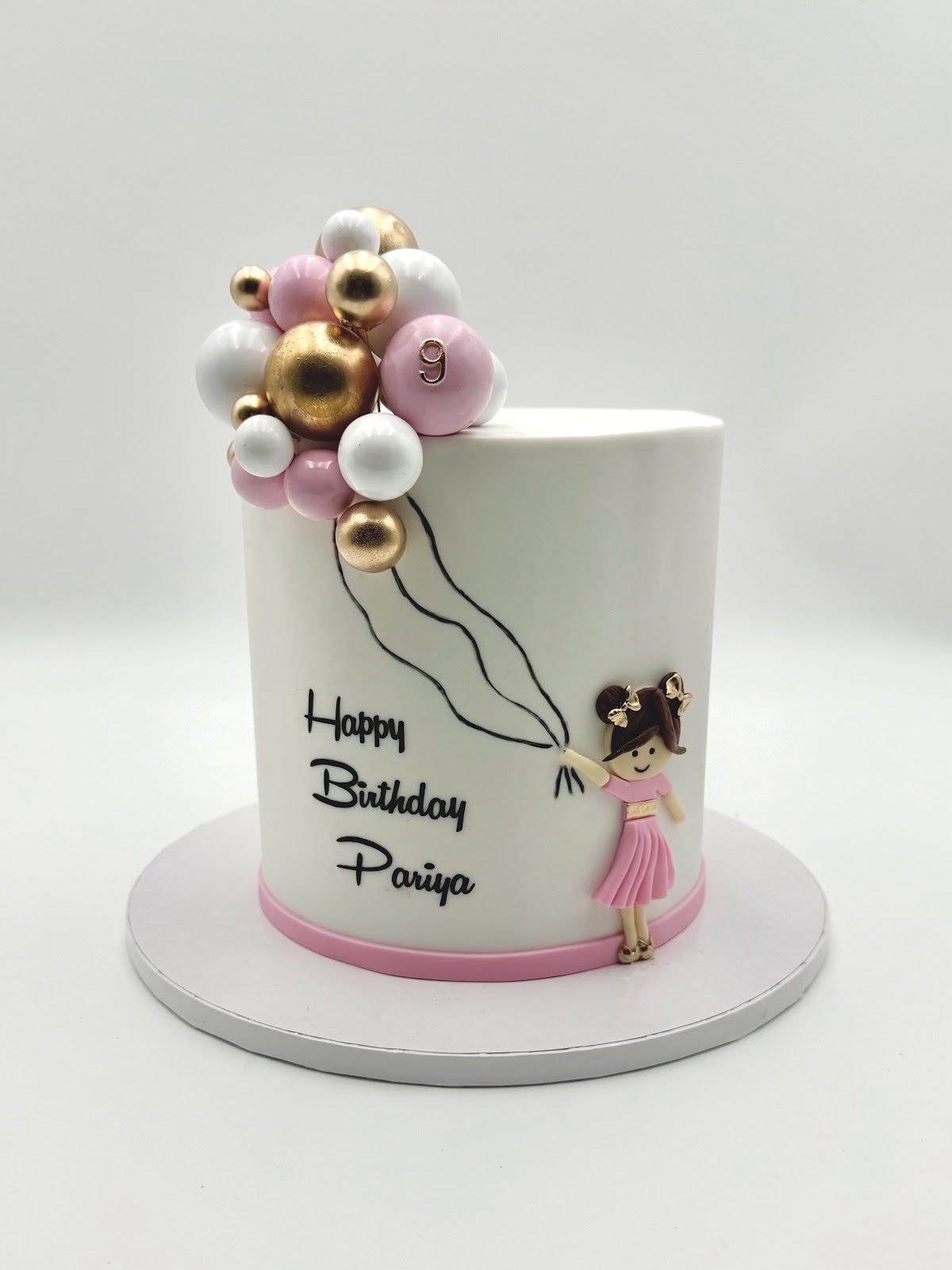Balloon Stack cake by NikooCake. Cascading edible chocolate balloons in your color story, hand-illustrated character, name piped in script. The crowd-pleaser.