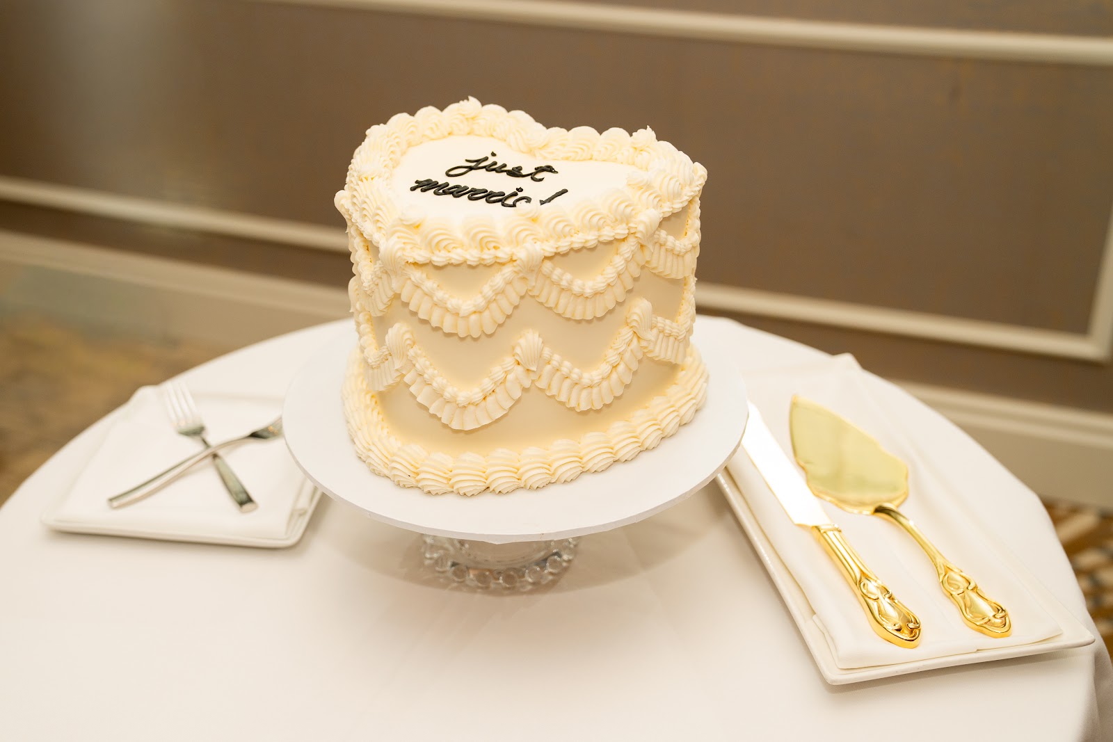 A heart-shape vintage piped cake by NikooCake, ivory buttercream lambeth scallops, 'just married' scripted on top