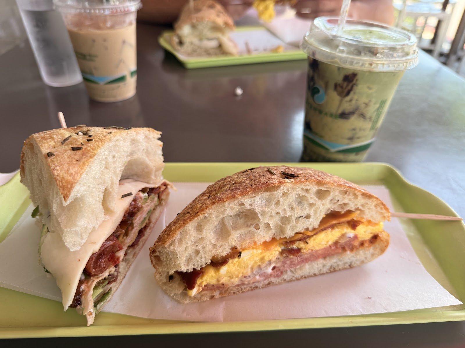 Breakfast Sandwich at Noonerz. Scrambled eggs, bacon, cheddar, onion, tomato, mayo on ciabatta. Pair it with a brown-sugar oatmilk latte.