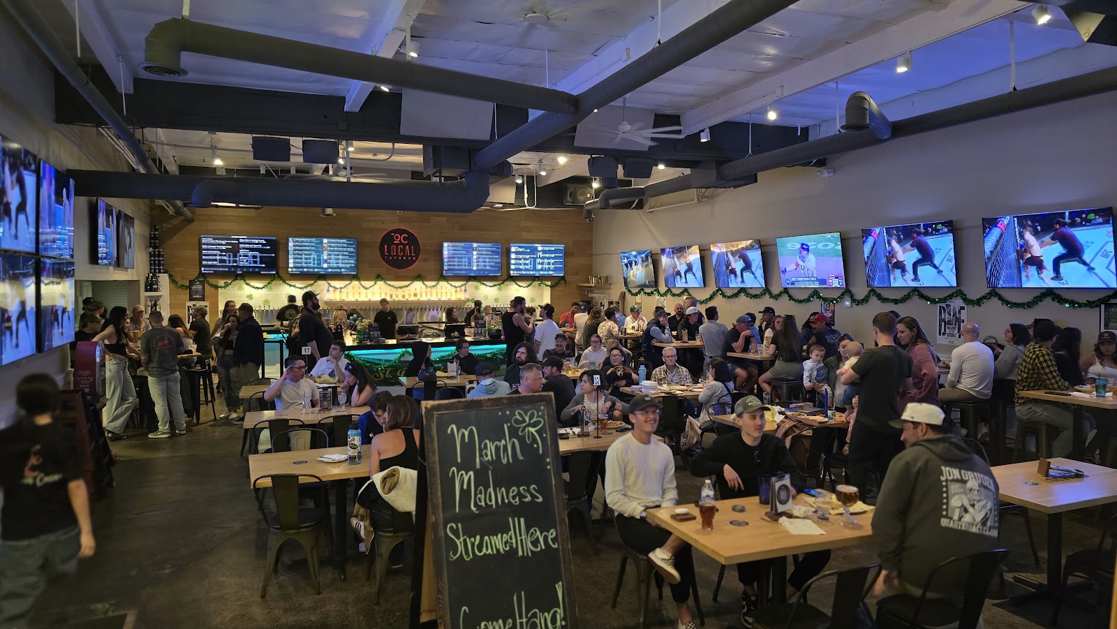 Inside OC Local Taproom: taps lined along the bar, warm lighting, family-friendly room