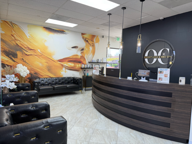 The OC Weight Loss & Med Spa reception with its warm gold mural and monogram wall