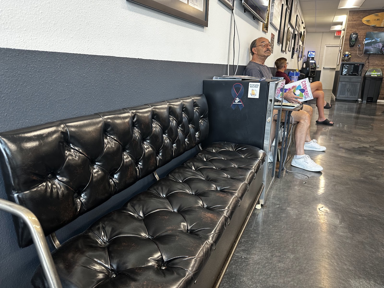 The leather chesterfield waiting bench inside Offshore Barber Shop