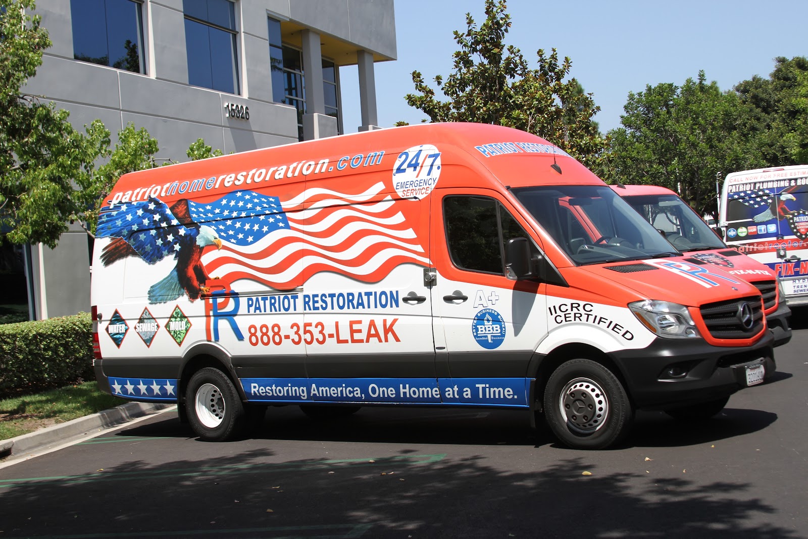 Flag-wrapped Patriot Plumbing emergency van, 24/7 service, parked outside an Irvine office