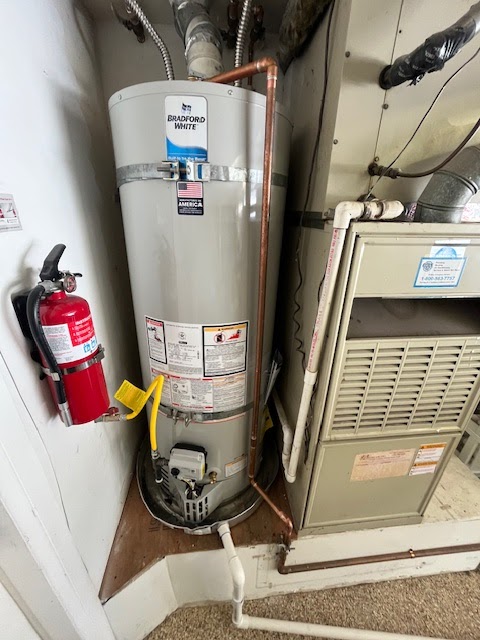 New Bradford White water heater installed by Patriot Plumbing next to a furnace