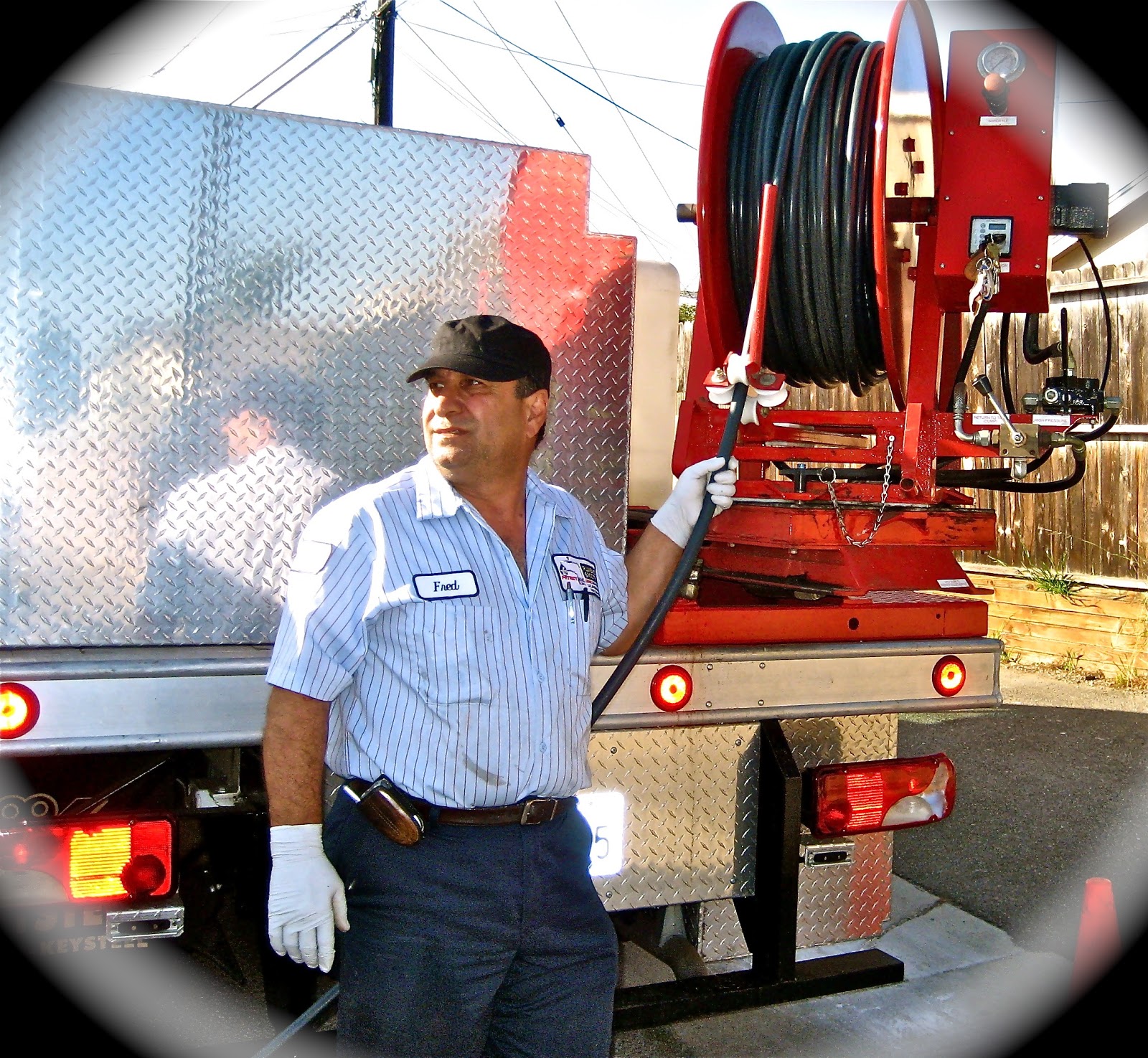 Patriot Plumbing technician beside a truck-mounted hydro jetting reel