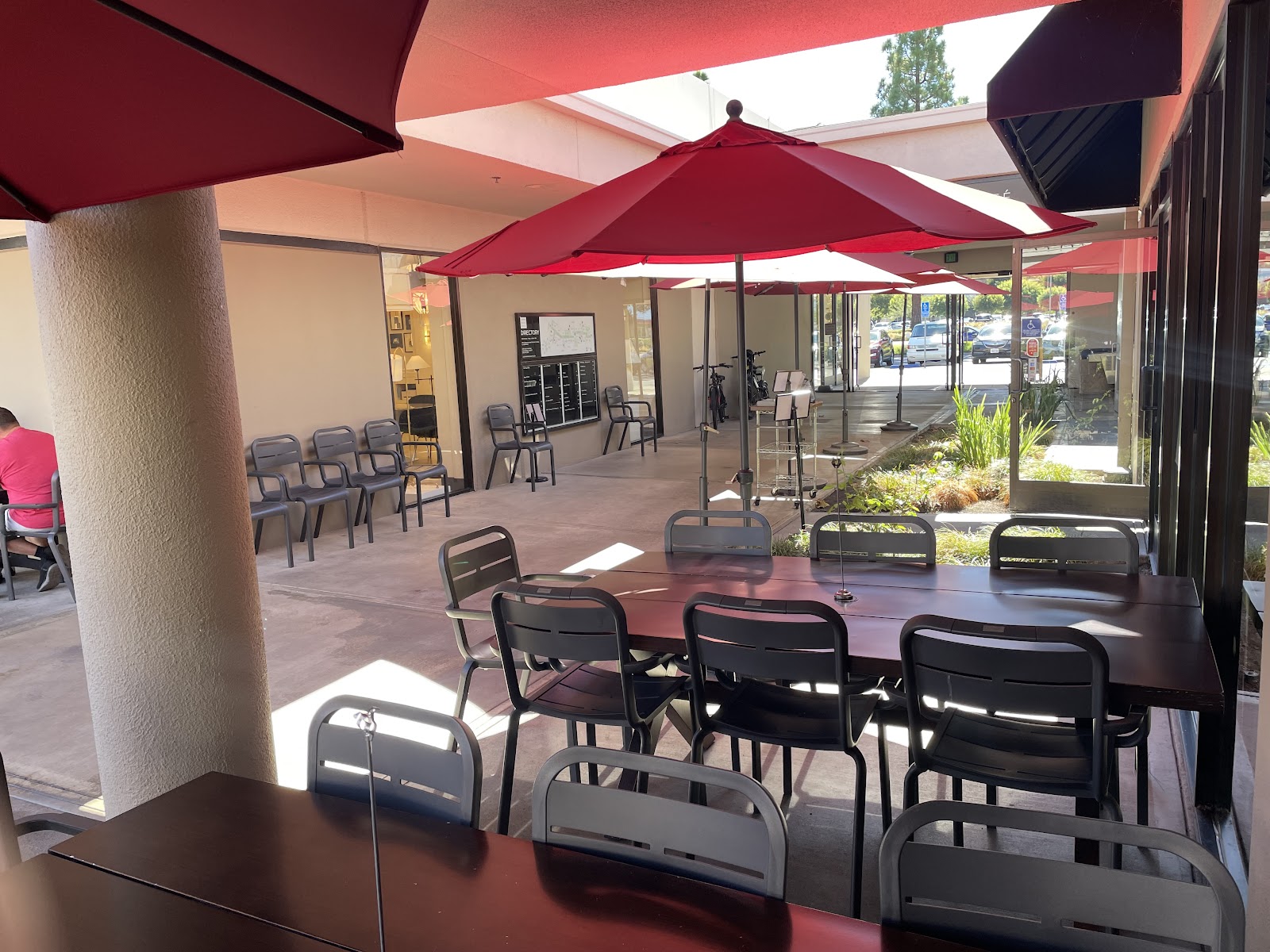 The patio at Plumeria Cafe with red umbrellas and an open courtyard, Laguna Niguel