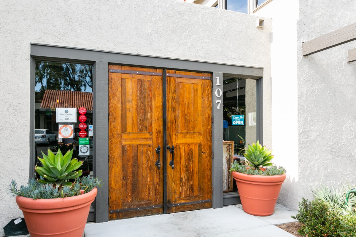 The dark-wood front door at Pub Thirty Two, succulents in clay pots either side
