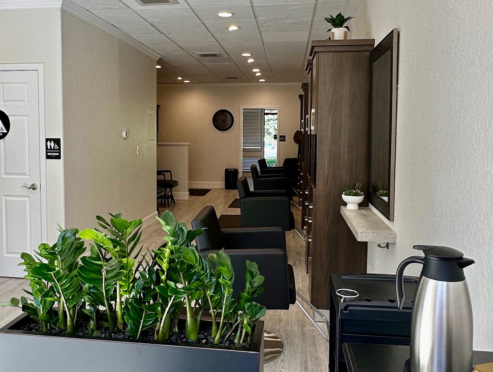 Salon Sage waiting area with plants and modern light