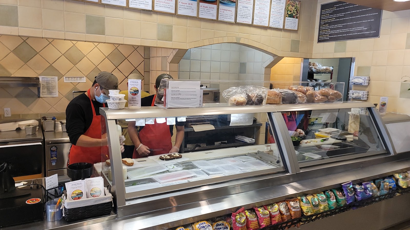 Inside Second Reef Deli, the counter, the menu board, surfboards on the wall
