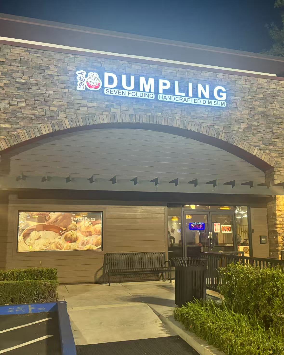 The lit Seven Folding storefront at night