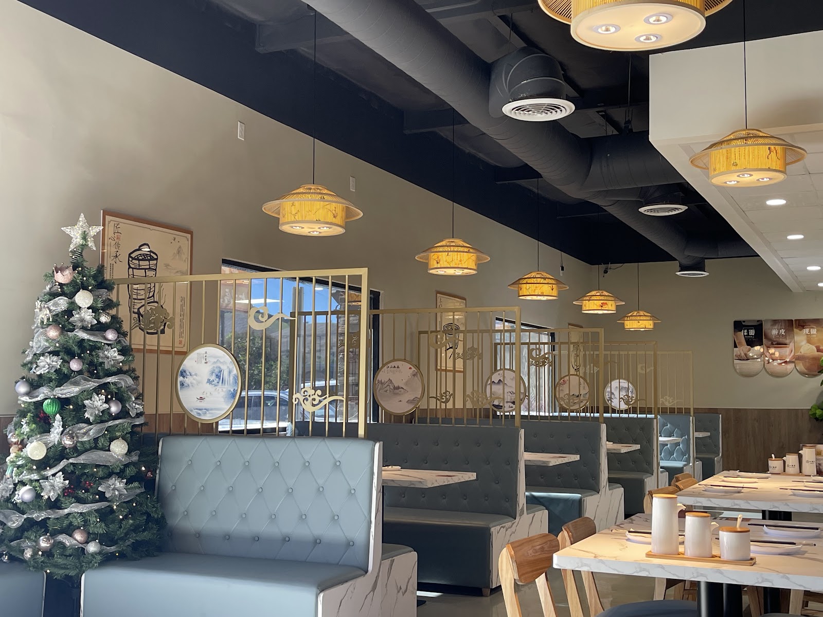 The Seven Folding dining room with woven pendant lamps, white marble tables, and warm gold partitions