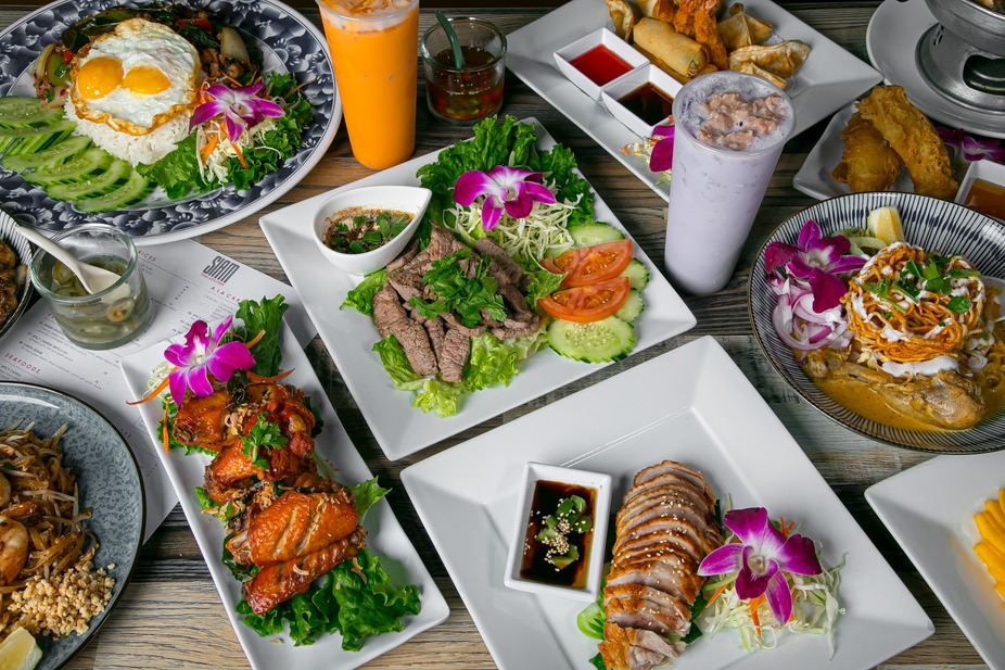A milder Thai spread at SIAM with orange chicken, sliced pork, and a sweet taro coconut drink