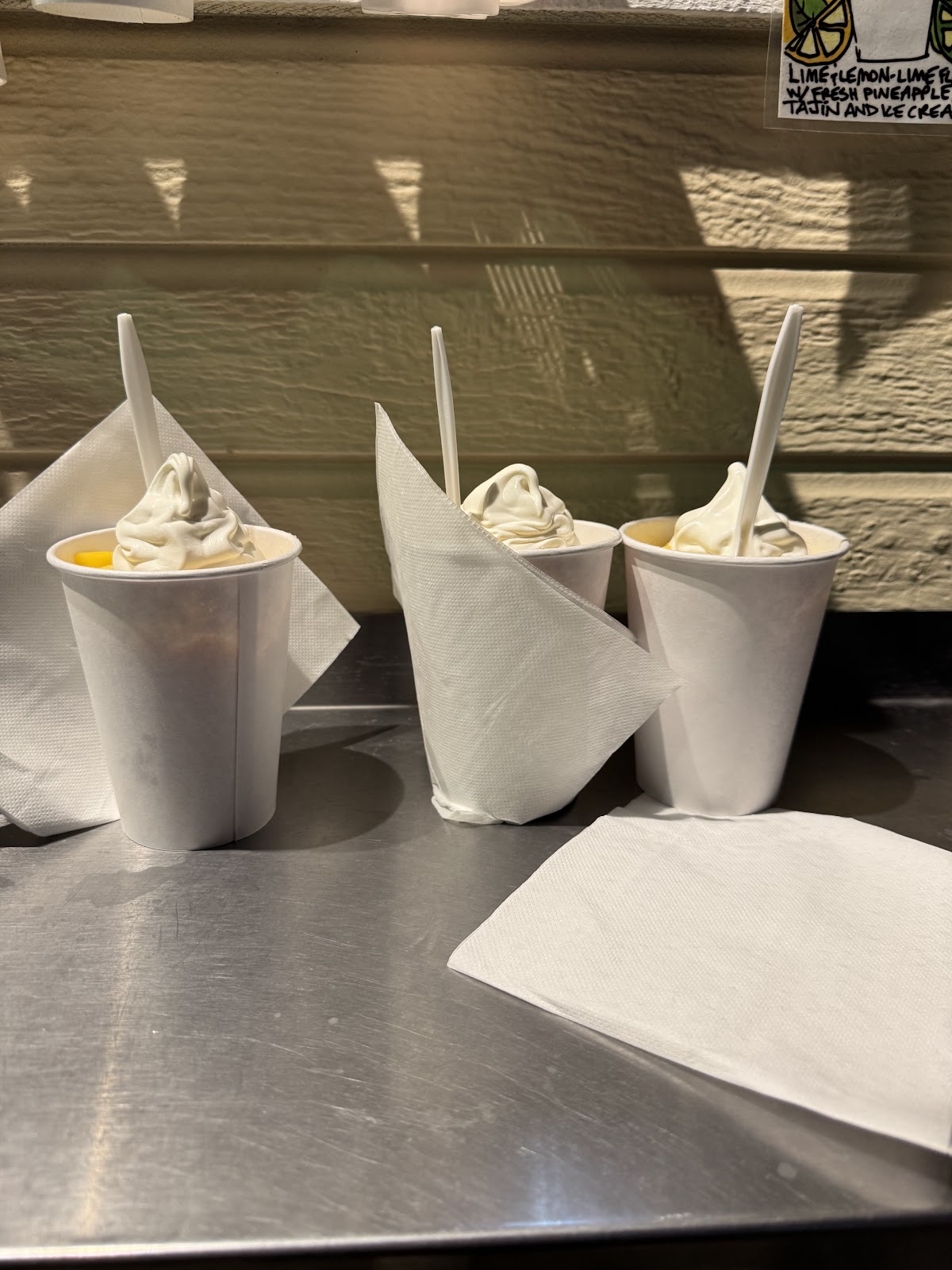 Three cups of soft serve with white napkins, lined up on the counter at Sno 2 Go