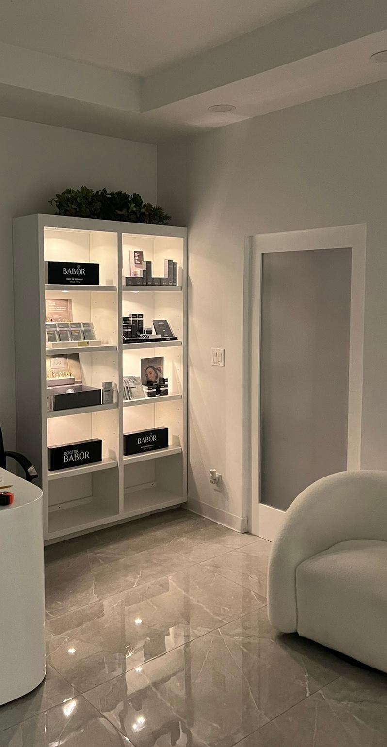 The lit BABOR retail shelving and a soft boucle chair in the calm interior of Swan Med Spa