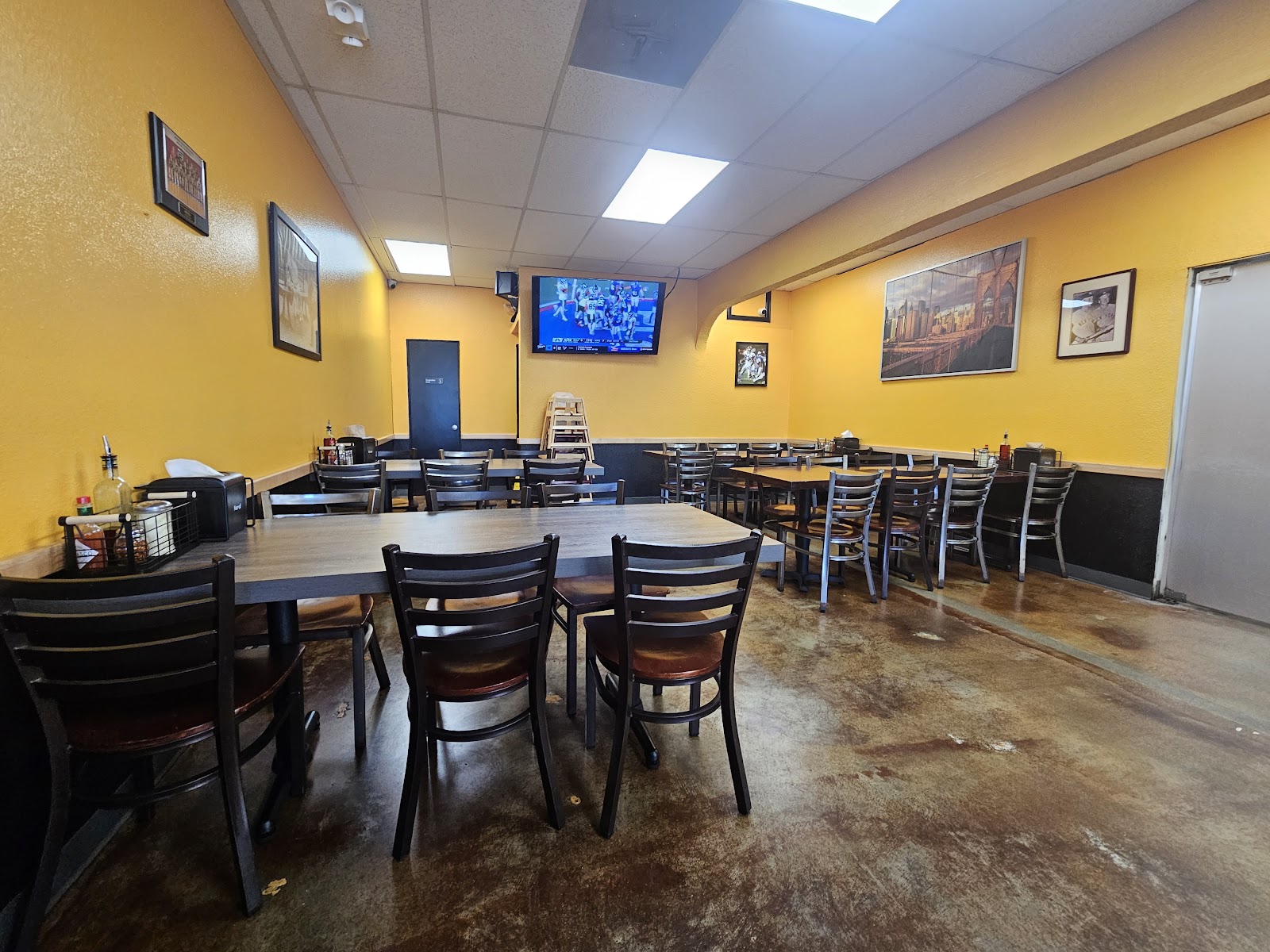 Inside Terra Mia Pizzeria, the warm yellow walls, Brooklyn-bridge canvas print, family-style seating